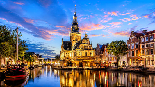 Breedbeeldfoto van de historische binnenstad van Alkmaar, Nederland, met karakteristieke grachten, bruggen en traditionele Hollandse architectuur – sfeervolle 8K landmarkfoto voor meubels herstofferen en meubelstoffering in Alkmaa