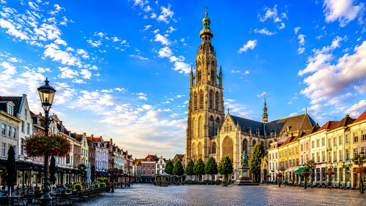 breedbeeldfoto van de Grote Kerk op de Grote Markt in Breda, Nederland, met historische gevels en sfeervolle architectuur bij zonsondergang – professionele landmarkfoto voor meubels herstofferen en meubelstoffering in Breda