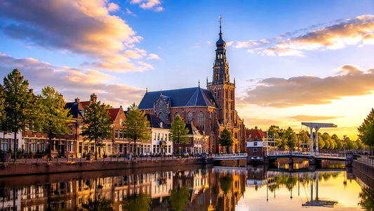 breedbeeldfoto van de Grote of Sint-Bavokerk aan het Spaarne in Puremend, Nederland, met historische gebouwen en weerspiegeling in het water – stijlvolle landmarkfoto voor meubels herstofferen en meubelstoffering in Puremend